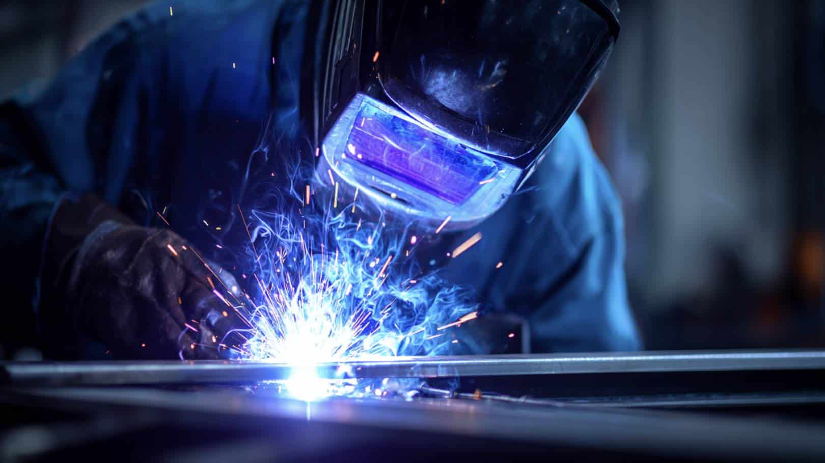 Welder creating sparks with welding torch