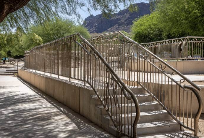 Curved metal handrails beside stairs.