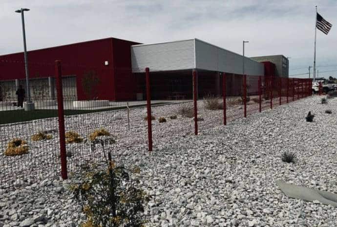 Red building with fenced gravel area.