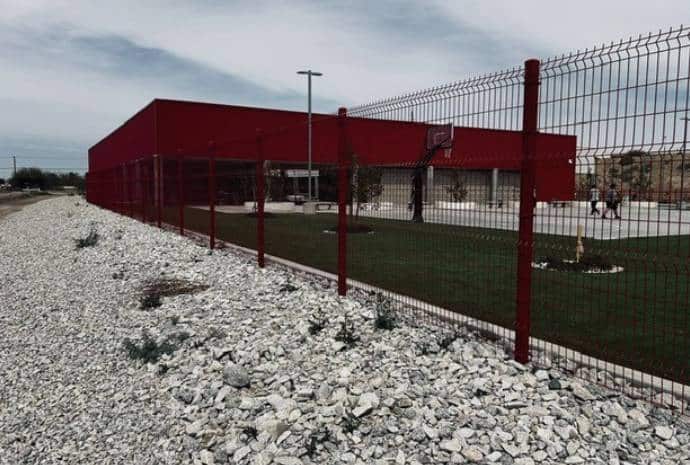 Red building surrounded by gravel fence.